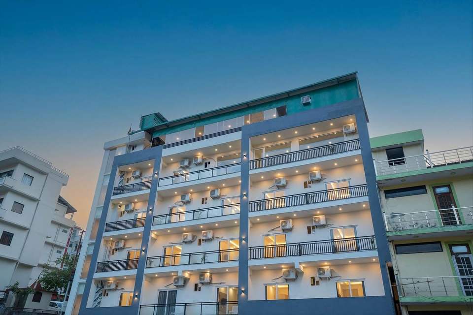 Alpine Retreat hotel building on Badrinath Marg with balconies on every floor against a blue sky, Tapovan, Rishikesh