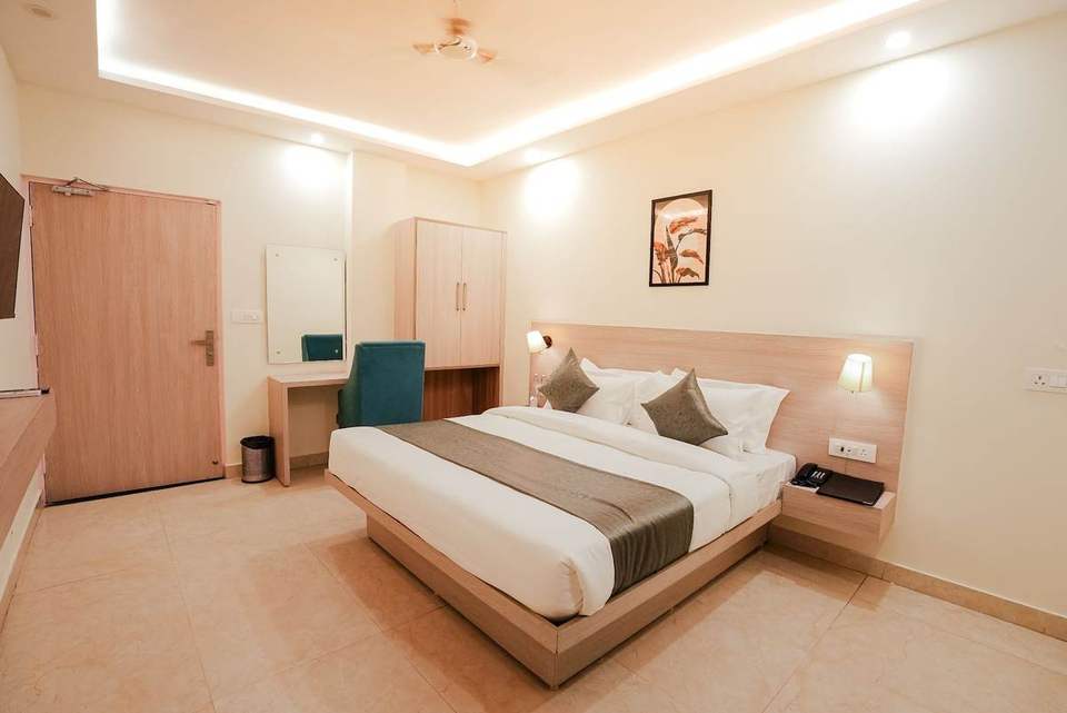 Bright Deluxe Room with king bed, dresser and wardrobe near the door at Alpine Retreat, Tapovan