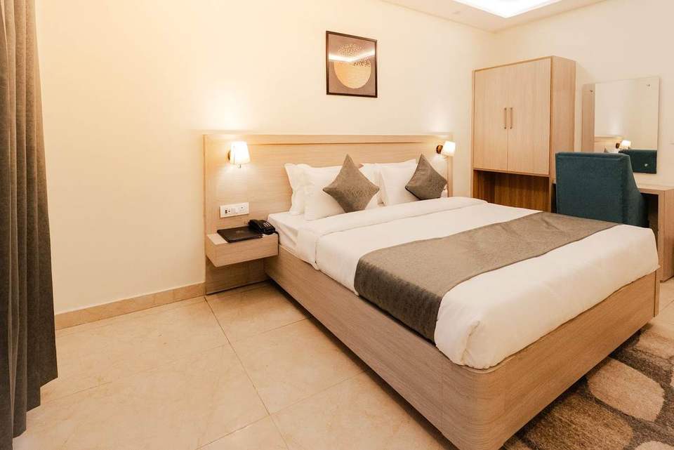 Standard Room with king bed, bedside lamps and armchair at Alpine Retreat, Tapovan, Rishikesh