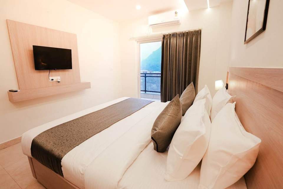 Standard Room with Smart TV on a wood panel and balcony window at Alpine Retreat, Rishikesh