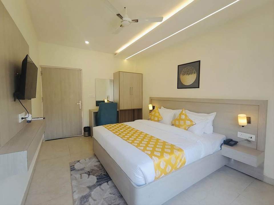 Super Deluxe Room with king bed, wall-mounted TV and wardrobe at Alpine Retreat, Tapovan, Rishikesh